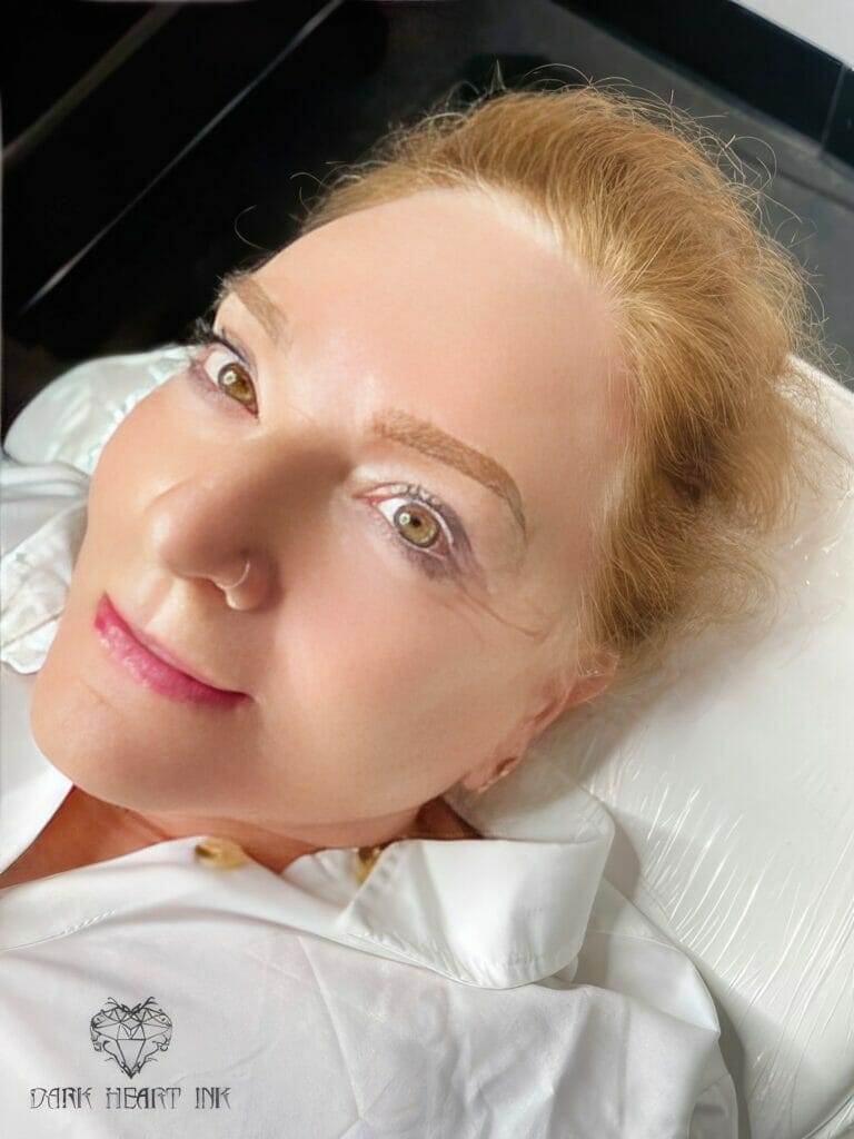 A woman named Amy is lying on a bed wearing a white shirt.