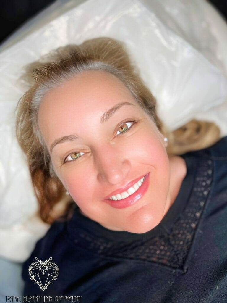 A woman named Amy lying on a bed with a smile on her face.