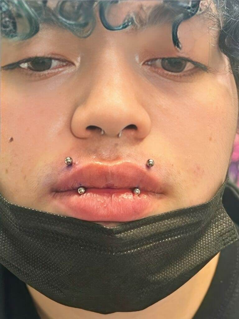 A man with multiple facial piercings.