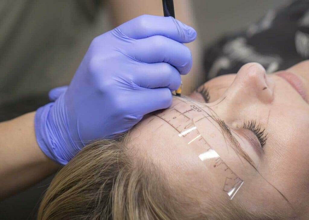 A woman receiving microblading for her eyebrows.