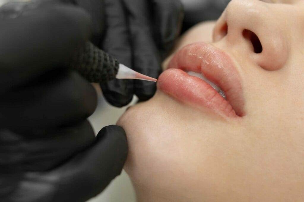 A woman undergoes contact lip tattooing.