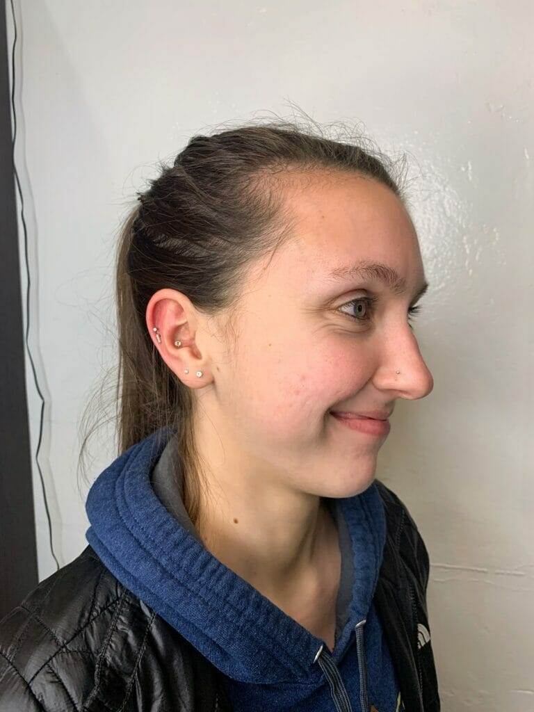 A young woman Steve smiling in front of a mirror.