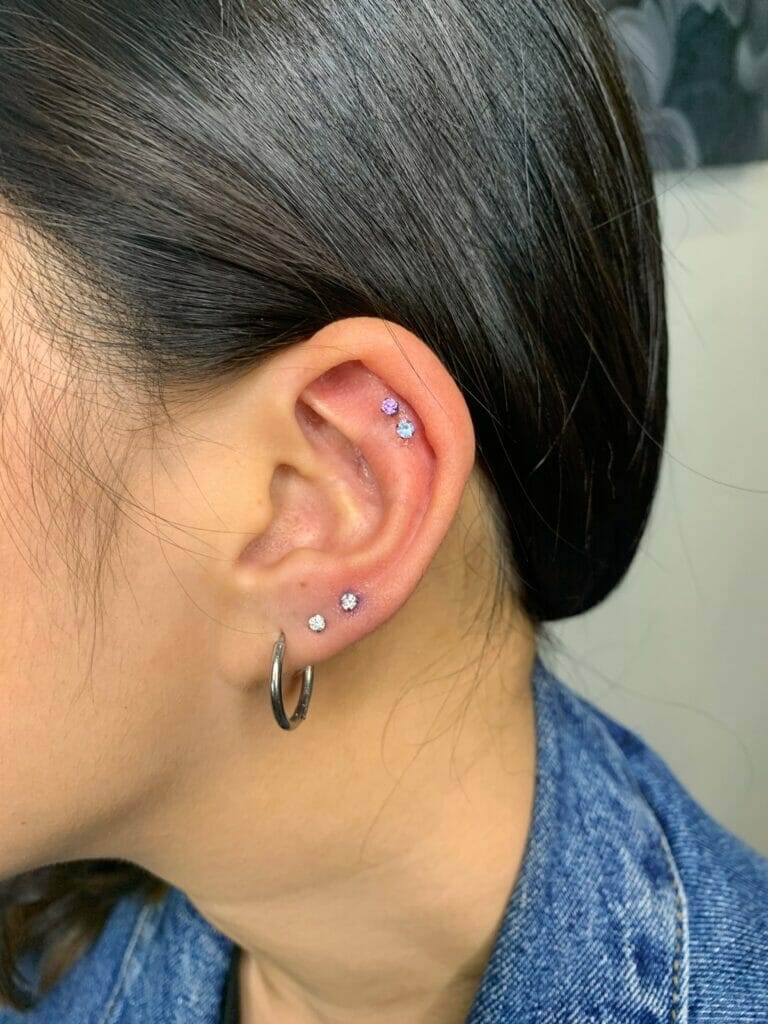 A woman with two piercings on her ear, named Pure.