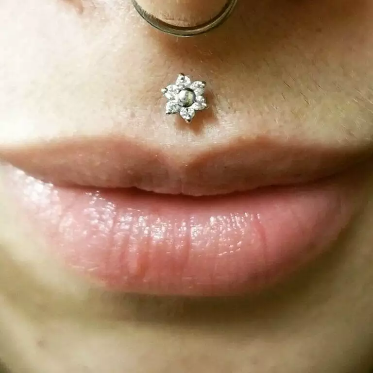 A close up of a woman with a nose piercing by Nathan Atoui.