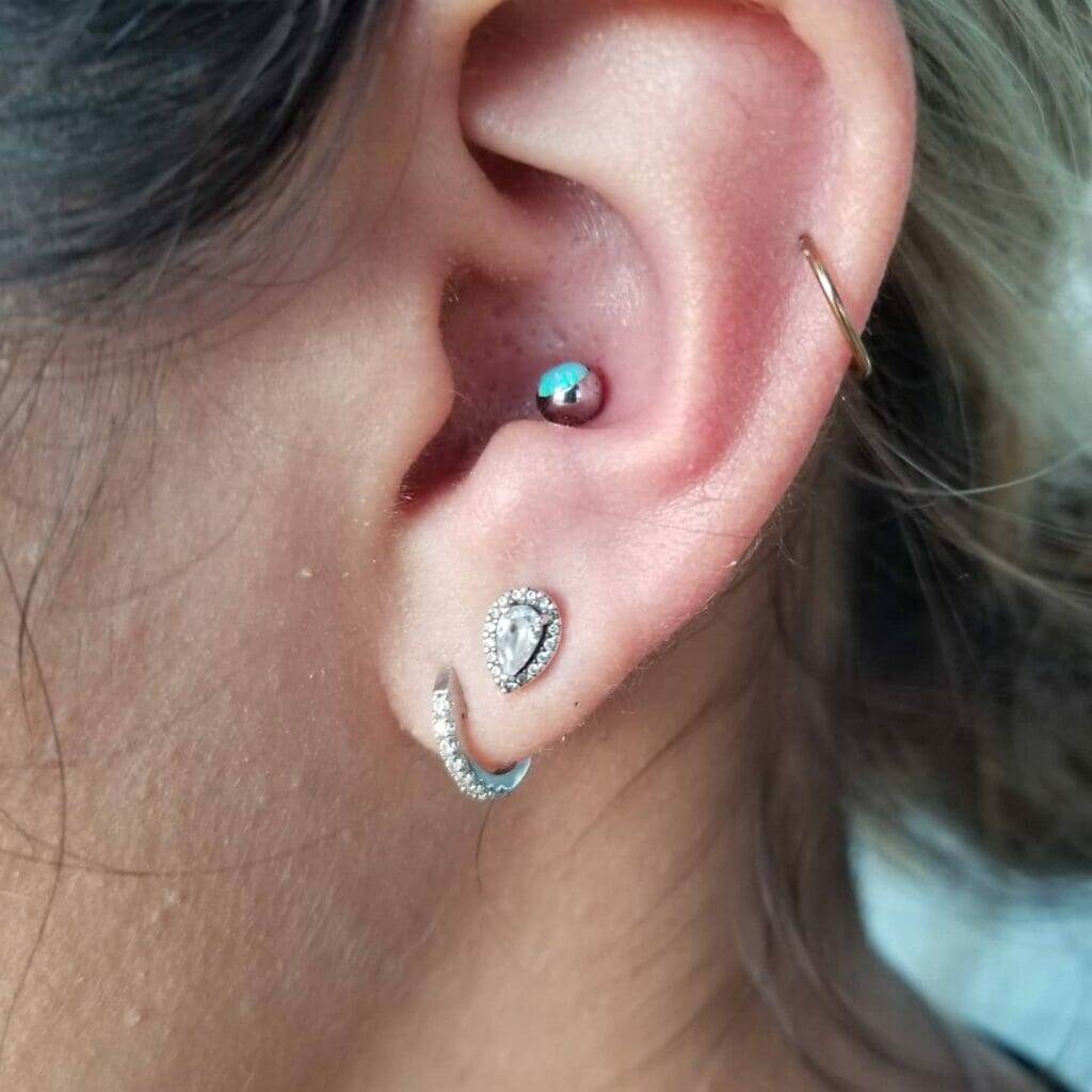 A woman's ear with a piercing by Nathan Atoui.