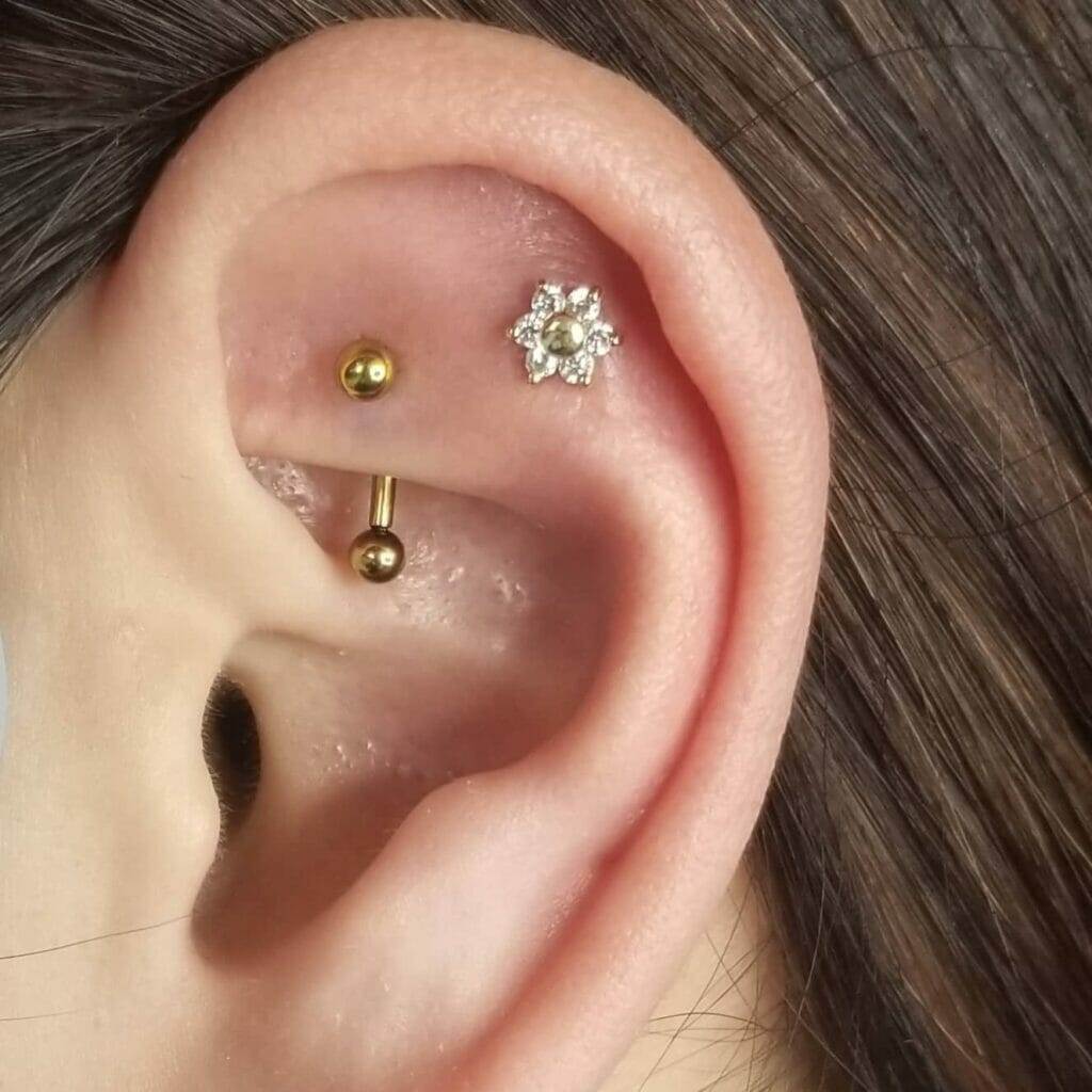 A woman's ear with a flower piercing by Nathan Atoui.