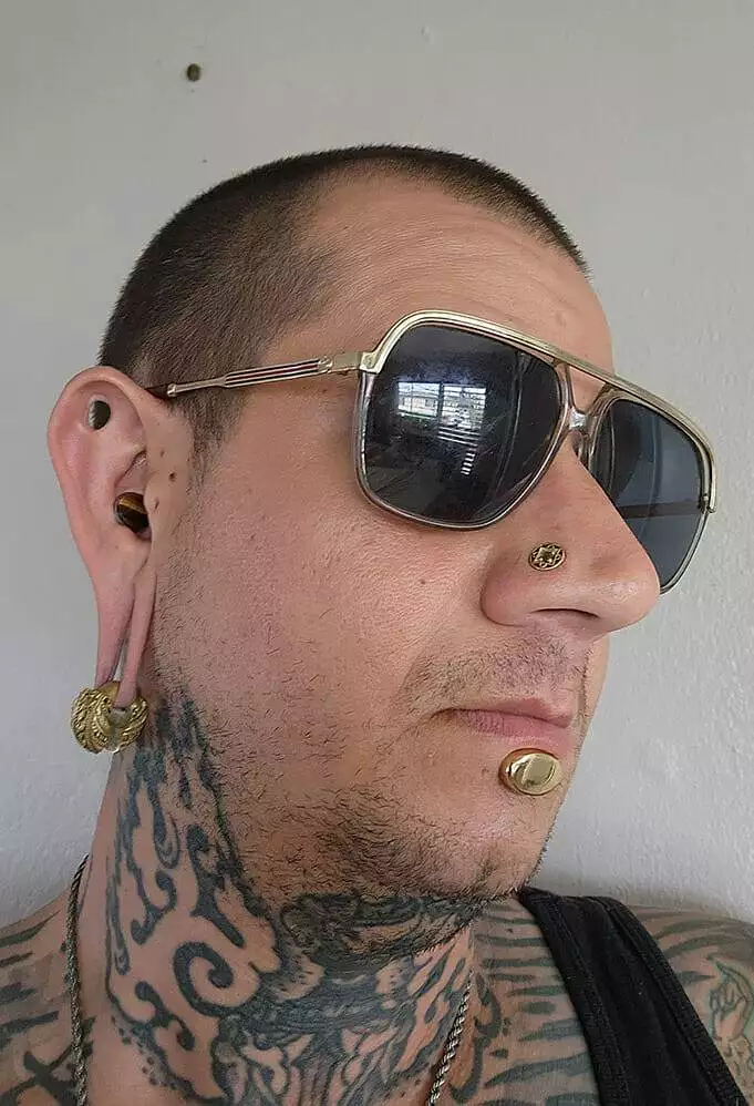 A tattooed artist wearing sunglasses.