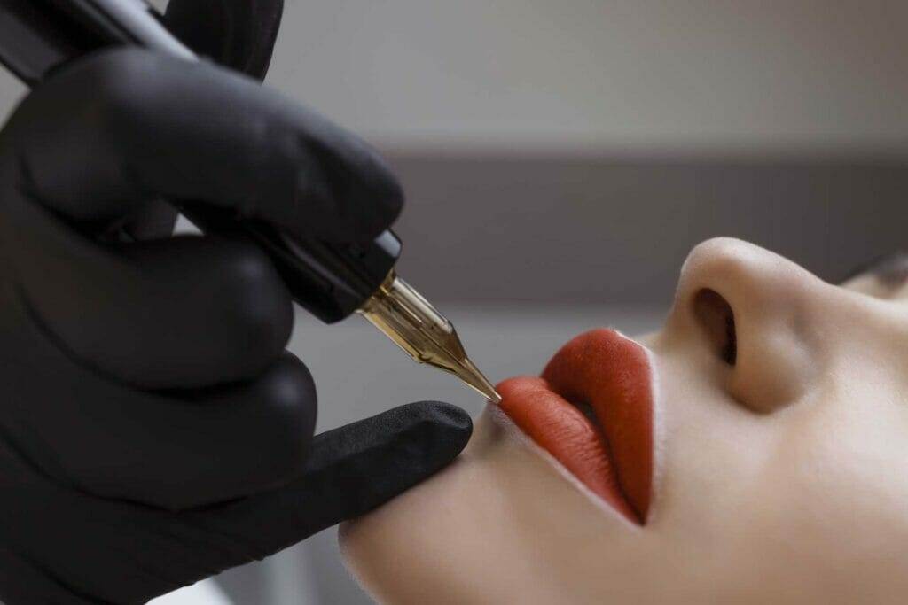 A woman getting her lips tattooed at home.